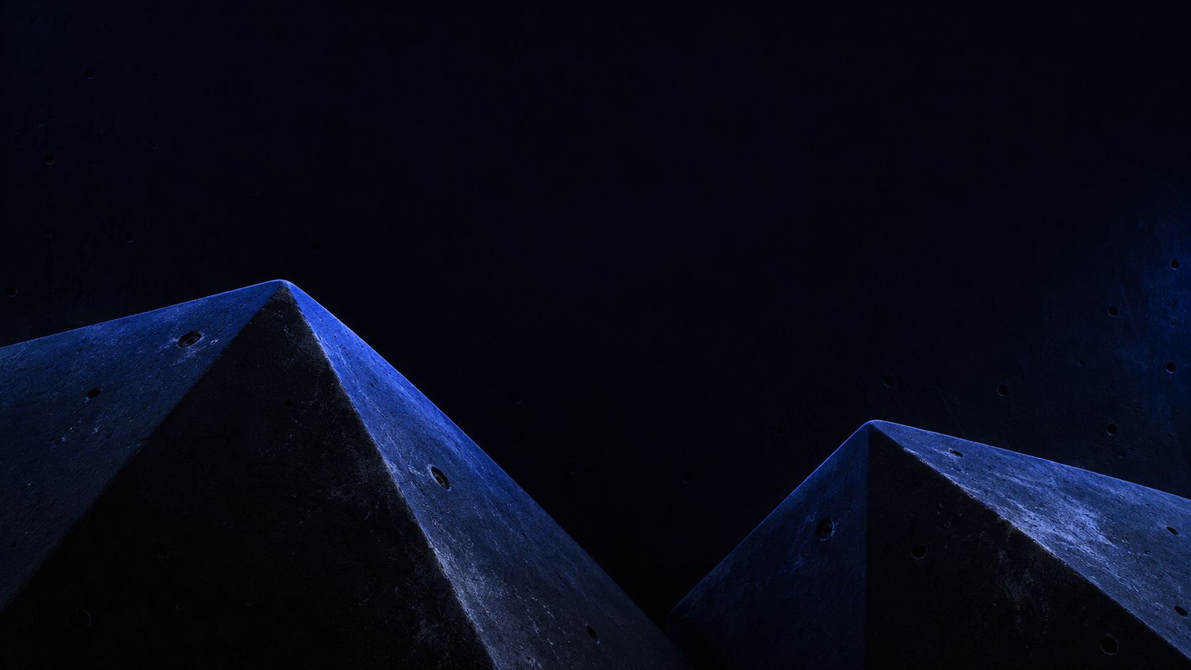 Blue-lit climbing volumes against a dark wall